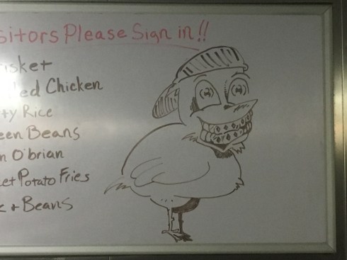 Picture of a chicken wearing a baseball cap backwards and smiling, revealing elaborately jeweled teeth