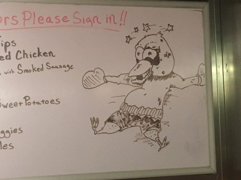 Picture of a chicken, wearing boxing shorts and boxing gloves. He is laying on the ground with a black eye, missing teeth and stars spinning around his head